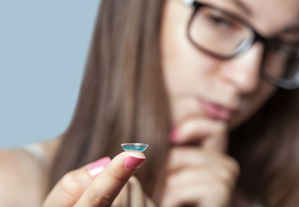 woman wondering whether to try contact lens