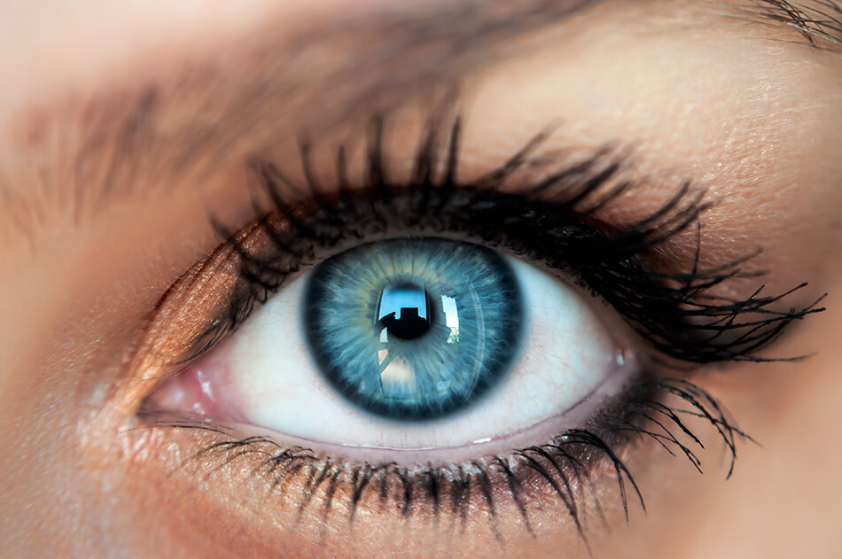 close up of woman’s eye with beautiful blue colored contact lens