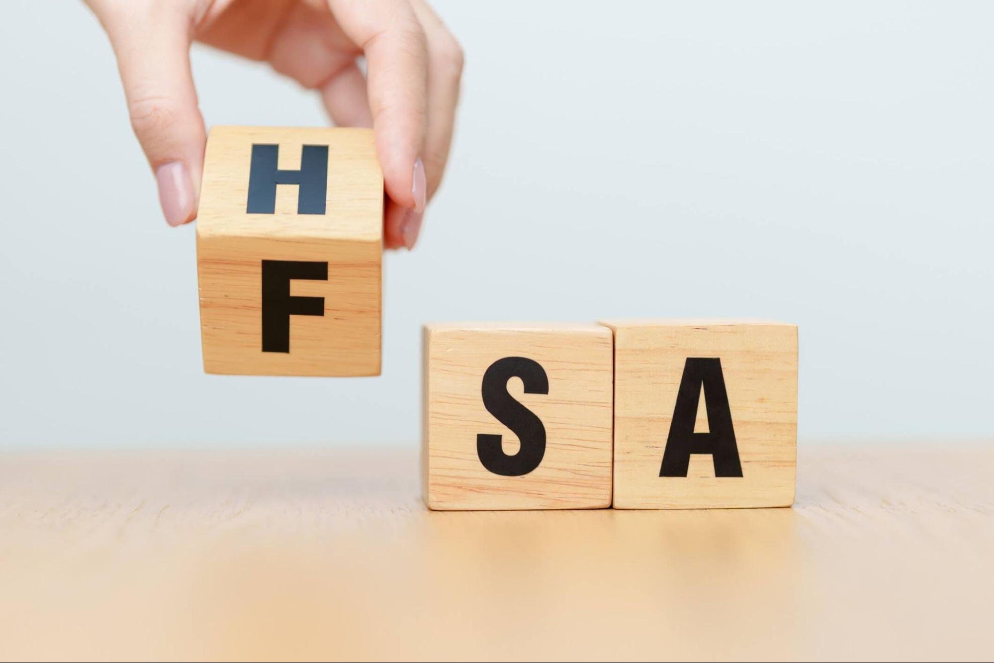 Wooden letter blocks showing FSA and HSA abbreviations for flexible and health savings accounts