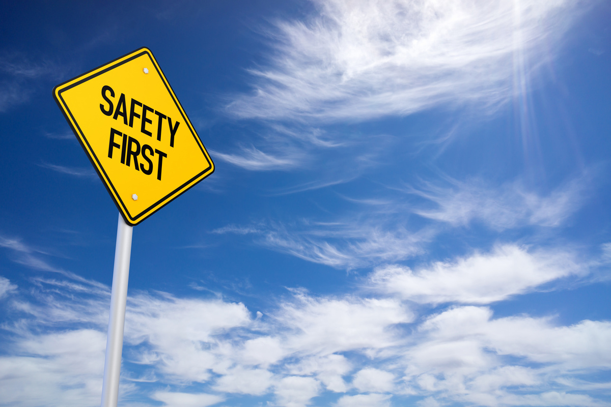 yellow sign saying “safety first” against blue sky