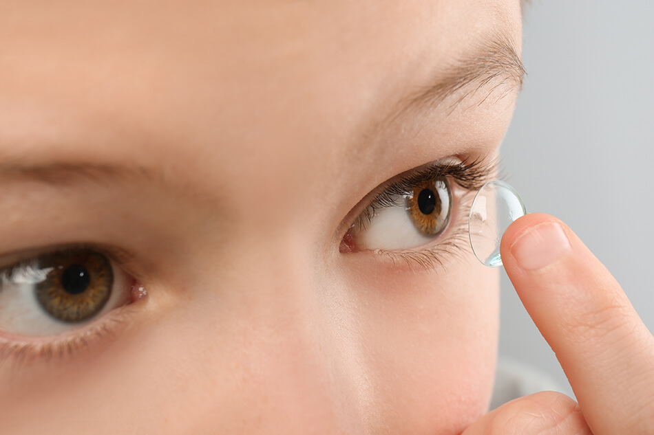 Young boy putting in a contact lens
