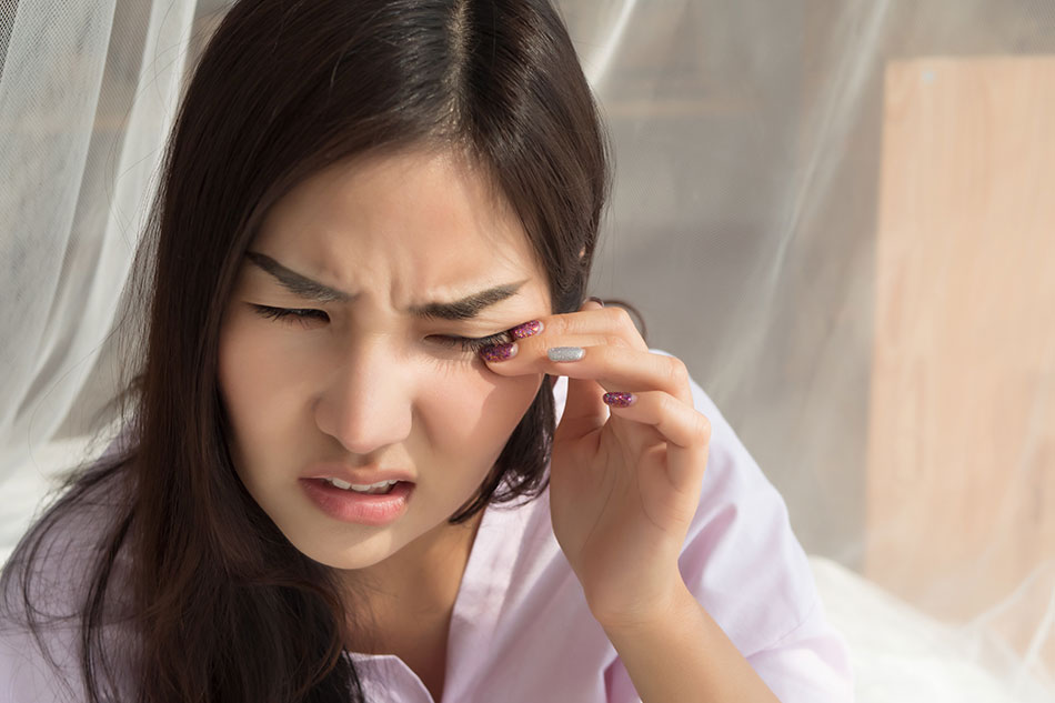 Young woman suffering from dry eyes with contacts